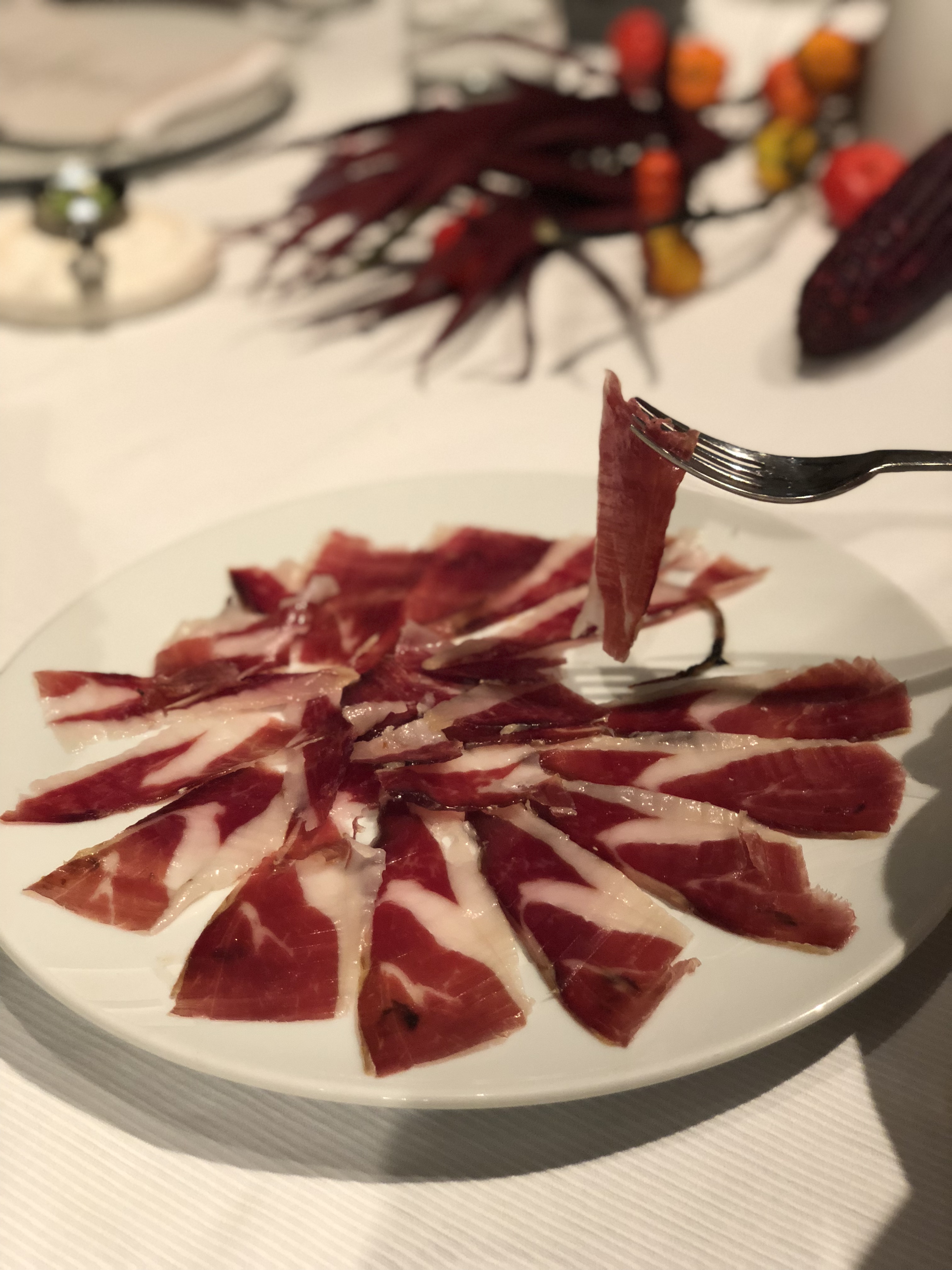 Freshly cut Iberico jambon, held up by a fork