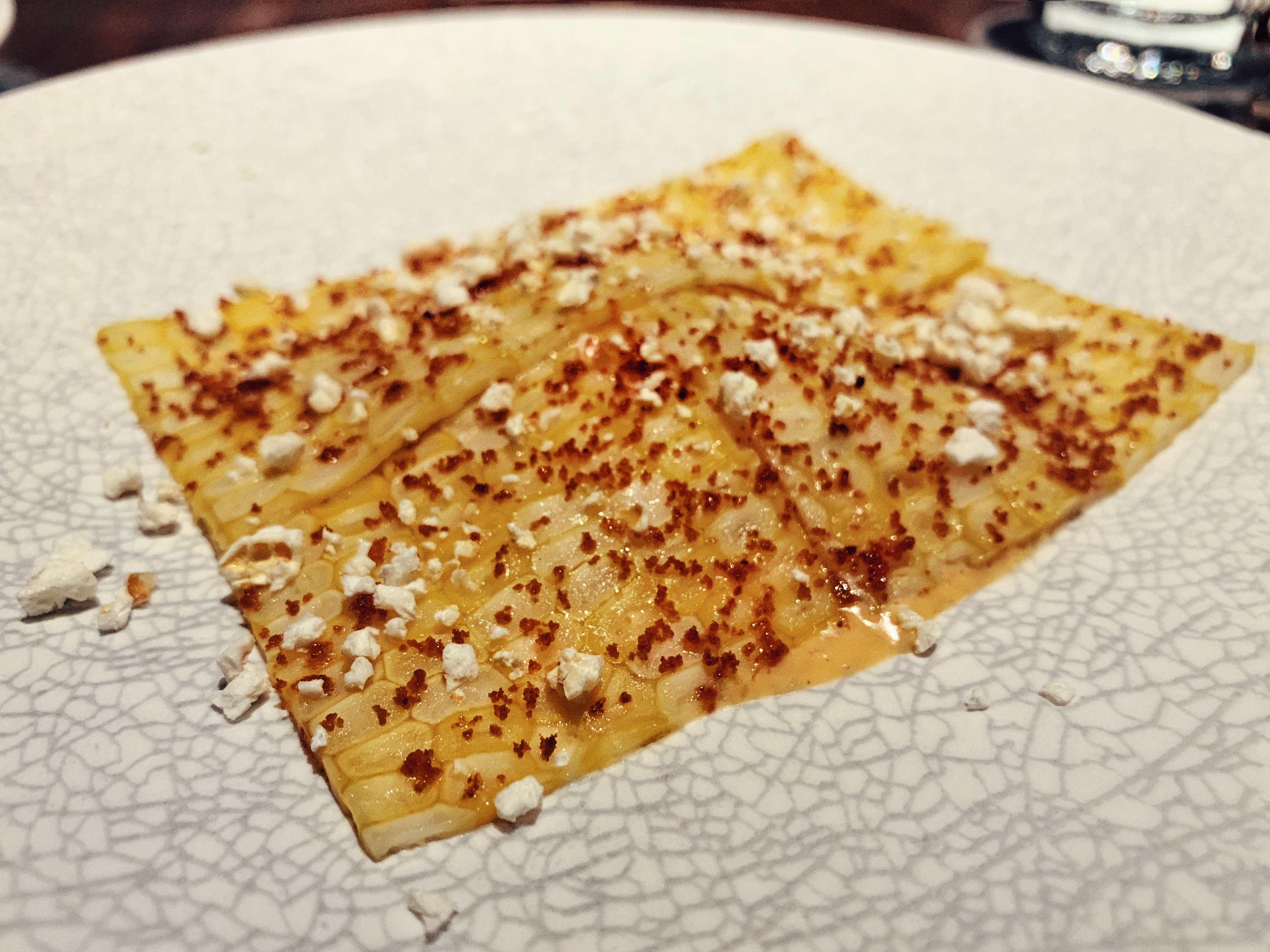 Thinly sliced corn with popped grains garnish