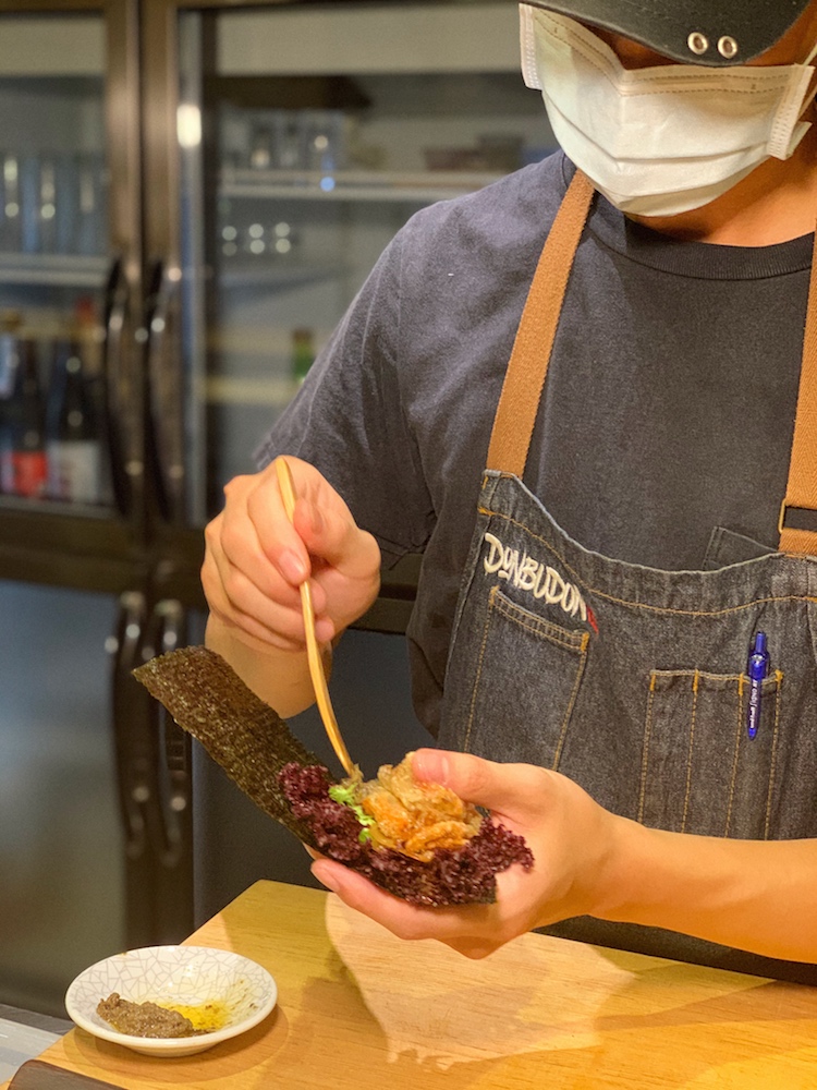 The entire soft shell crab is placed on a bed of lettuce and seaweed