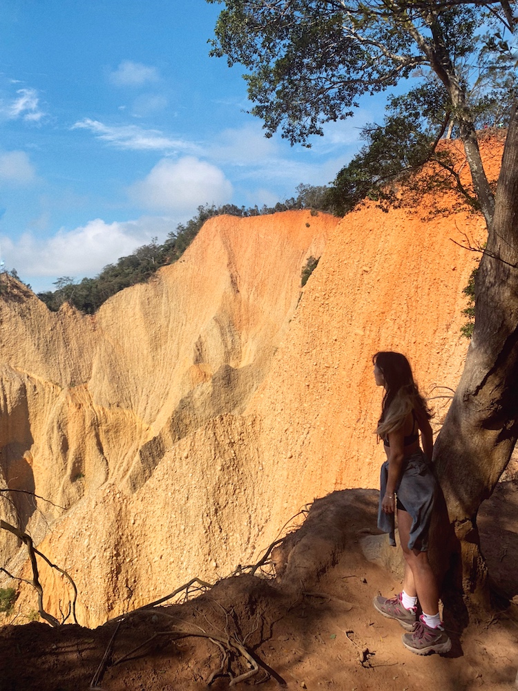 Hiker carefully looking over the edge of a jagged peak.