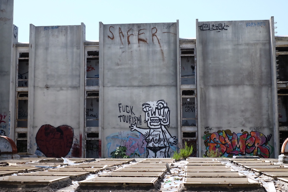 Fuck tourism graffiti in the abandoned hotel